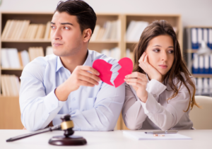 Man and woman standing side by side with a broken heart between them, representing relationship breakdown and property division